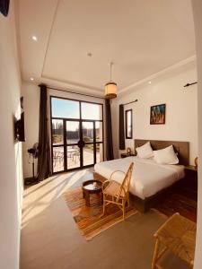 a bedroom with a bed and a large window at Dar Ayman Essaouira in Essaouira +160 photos