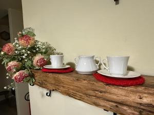 two tea cups and saucers on a counter with flowers at Casa nella Corte in Bellano