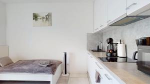 a white kitchen with a bed in the middle at Apartament Fibra Bounty in Rybnik