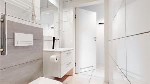 a white bathroom with a toilet and a sink at Apartament Fibra Bounty in Rybnik +18 photos