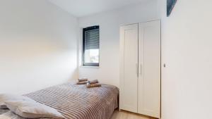 a bedroom with a bed with two teddy bears on it at Apartament Fibra Bounty in Rybnik