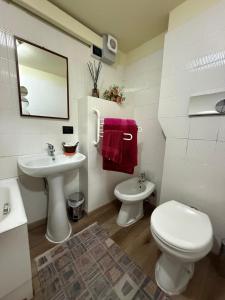 a white bathroom with a toilet and a sink at Casa nella Corte in Bellano