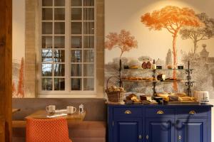 a kitchen with blue cabinets and a table with food at Château Saint Gilles - Bayeux in Guéron