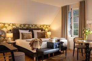 a hotel room with a bed and a table and chairs at Château Saint Gilles - Bayeux in Guéron