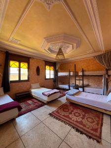 a large room with three beds and a ceiling at Berber Waves Surf House in Tamraght Ouzdar