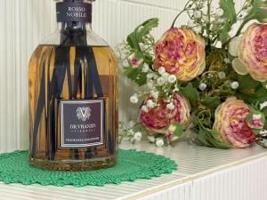 a bottle of wine sitting on a shelf with flowers at Casa nella Corte in Bellano +5 photos