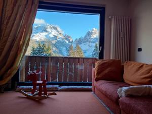 a living room with a large window with a mountain view at CAMPIGLIO Panorama sul Brenta in Madonna di Campiglio