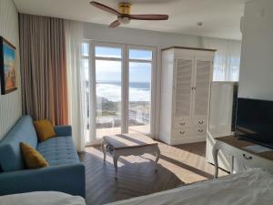 a living room with a blue couch and a television at Ocean View Apartments in Lourinhã