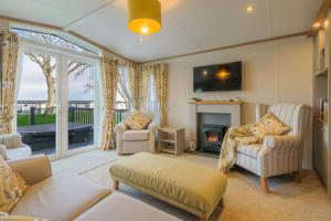 a living room with a couch and a fireplace at Hot Tub Lodge 31 Cameron, St Andrews in St. Andrews