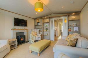 a living room with a couch and a fireplace at Hot Tub Lodge 31 Cameron, St Andrews in St. Andrews