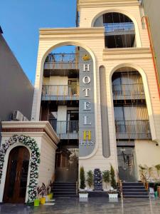 ein Gebäude mit einem Hotelschild an der Seite in der Unterkunft Hotel H Plus in Kurukshetra