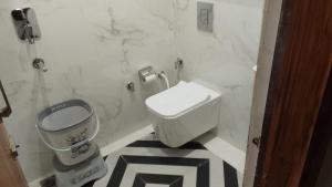 ein Badezimmer mit Toilette und Mülleimer in der Unterkunft Hotel H Plus in Kurukshetra + 14 Fotos