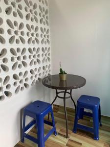 a table and two blue stools in front of a wall at CANTINHO SÃO PEDRO in Maceió +4 photos
