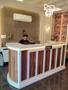 ein Mann sitzt an einer Bar in einem Zimmer in der Unterkunft Hotel H Plus in Kurukshetra