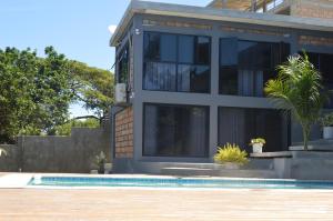 a house with a swimming pool in front of it at lodge3a in Ponta do Ouro