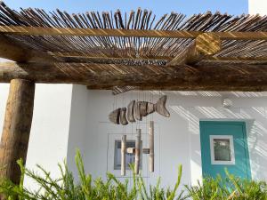 a house with a wooden fence in front of it at Pego Beach House in Grândola