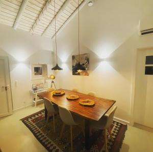 a dining room with a wooden table and chairs at Pego Beach House in Grândola