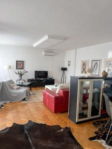 a living room with a red couch and a tv at Villa Mina Kladovo, 5-Bedroom Villa with Pool for up to 12 People in Kladovo
