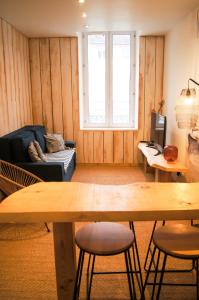 a living room with a table and chairs and a television at Le Havre Familial - 5 couchages climatisé in Romans-sur-Isère