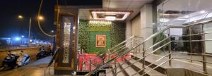 a building with a green wall with motorcycles on it at Hotel Cosmos in Lucknow