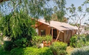 a house with an umbrella in a garden at Procida Camp & Resort - La Caravella in Procida