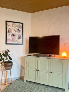 a flat screen tv on top of a white cabinet at Gartenblick in Blankenheim