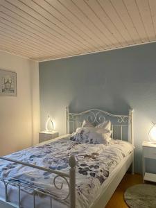 a bedroom with a white bed with two lamps at Gartenblick in Blankenheim