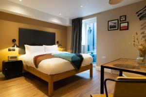a bedroom with a bed and a table and a desk at Lamington Apartments - London Hammersmith in London