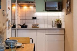 a small kitchen with white cabinets and a table at Lamington Apartments - London Hammersmith in London