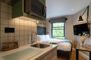 a kitchen with a sink and a bed in a room at Lamington Apartments - London Hammersmith in London +77 photos