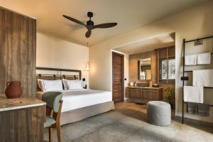 a bedroom with a bed with a ceiling fan at Enorme Infinity Elounda - Adults Only in Elounda +75 photos
