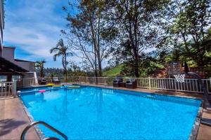 a large swimming pool with blue water at Chandys Windy Woods Munnar in Munnar
