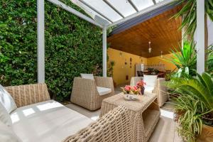 a patio with wicker chairs and tables and a hedge at Martina B&B in Agropoli