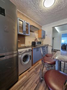 a kitchen with a washing machine and a table and chairs at Airida Forest Apartment in Druskininkai +15 photos