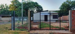 a fence with a gate in front of a house at Casa M&T in Encarnación