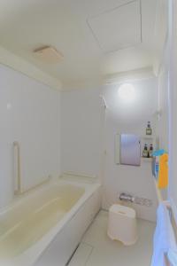 a white bathroom with a tub and a toilet at North Furano House in Kami-furano +41 photos
