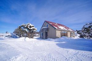 a house in a snow covered field with trees at North Furano House in Kami-furano