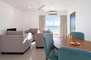 a living room with a table and chairs and a couch at Corundum Breeze Negombo in Negombo