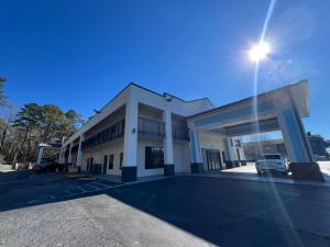 a building with a car parked in a parking lot at Speedway Inn & Suites Griffin US 19 in Griffin