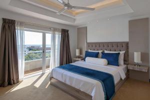 a bedroom with a large bed and a large window at Corundum Breeze Negombo in Negombo +28 photos