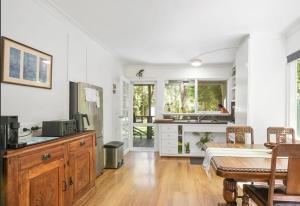 a kitchen and dining room with white walls and wood floors at Willows Cottage in Warburton +27 photos