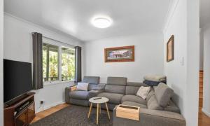 a living room with a couch and a tv at Willows Cottage in Warburton
