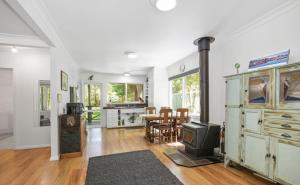 a living room with a fireplace and a stove at Willows Cottage in Warburton