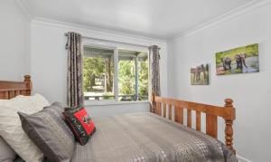 a bedroom with a bed and a window at Willows Cottage in Warburton