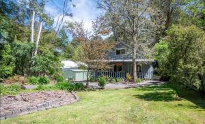 an exterior view of a house with a yard at Willows Cottage in Warburton