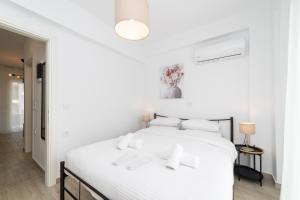 a white bedroom with a white bed with white pillows at Perla Stay Complex by Horizon Homes in Ofrínion