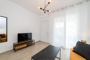 a living room with a tv and a couch at Perla Stay Complex by Horizon Homes in Ofrínion