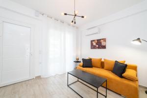 a living room with a yellow couch and a table at Perla Stay Complex by Horizon Homes in Ofrínion