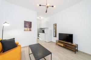 a living room with a couch and a flat screen tv at Perla Stay Complex by Horizon Homes in Ofrínion +18 photos