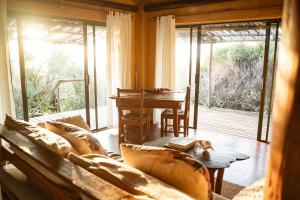 a living room with a couch and a table at Tofinho Beach House in Praia do Tofo